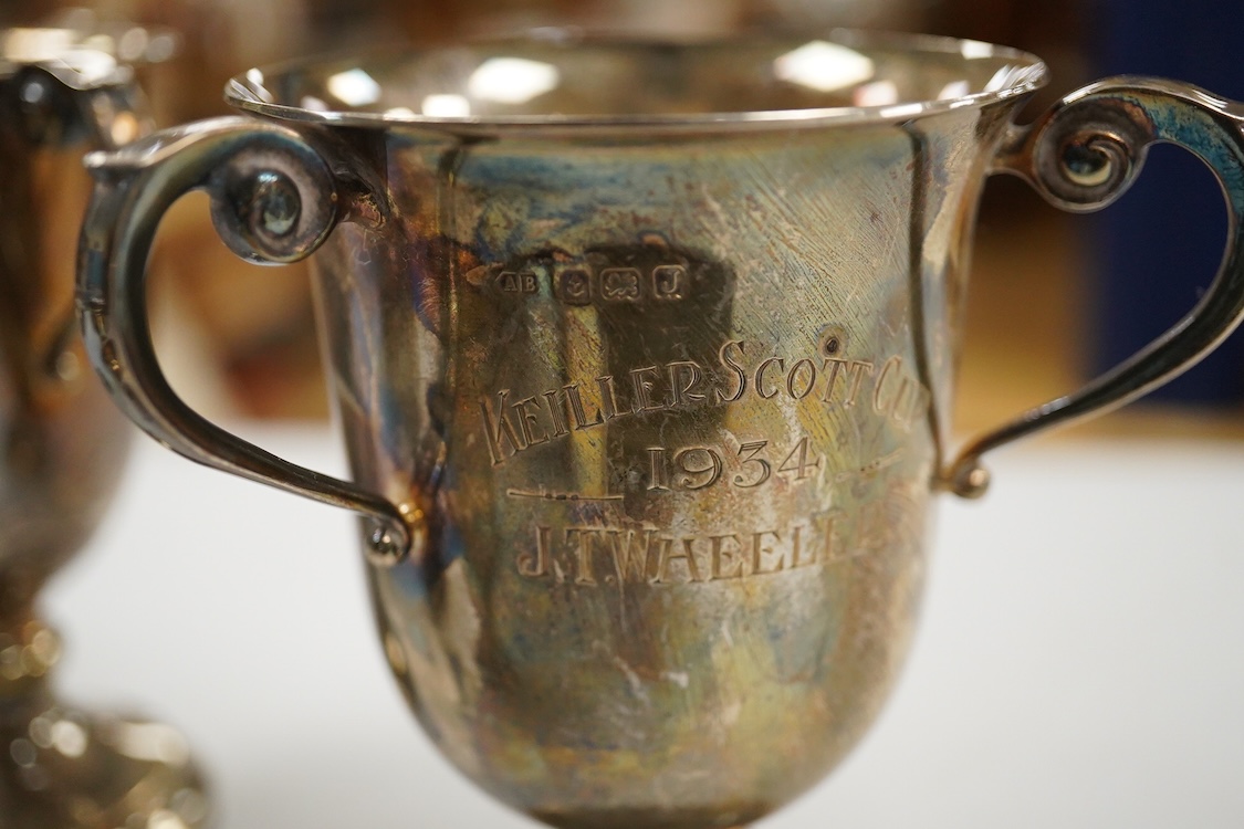 Five assorted George V silver trophy cups including two tri-handled, approx. 12.2cm and a silver bon-bon dish, with pierced border, 19.3oz.